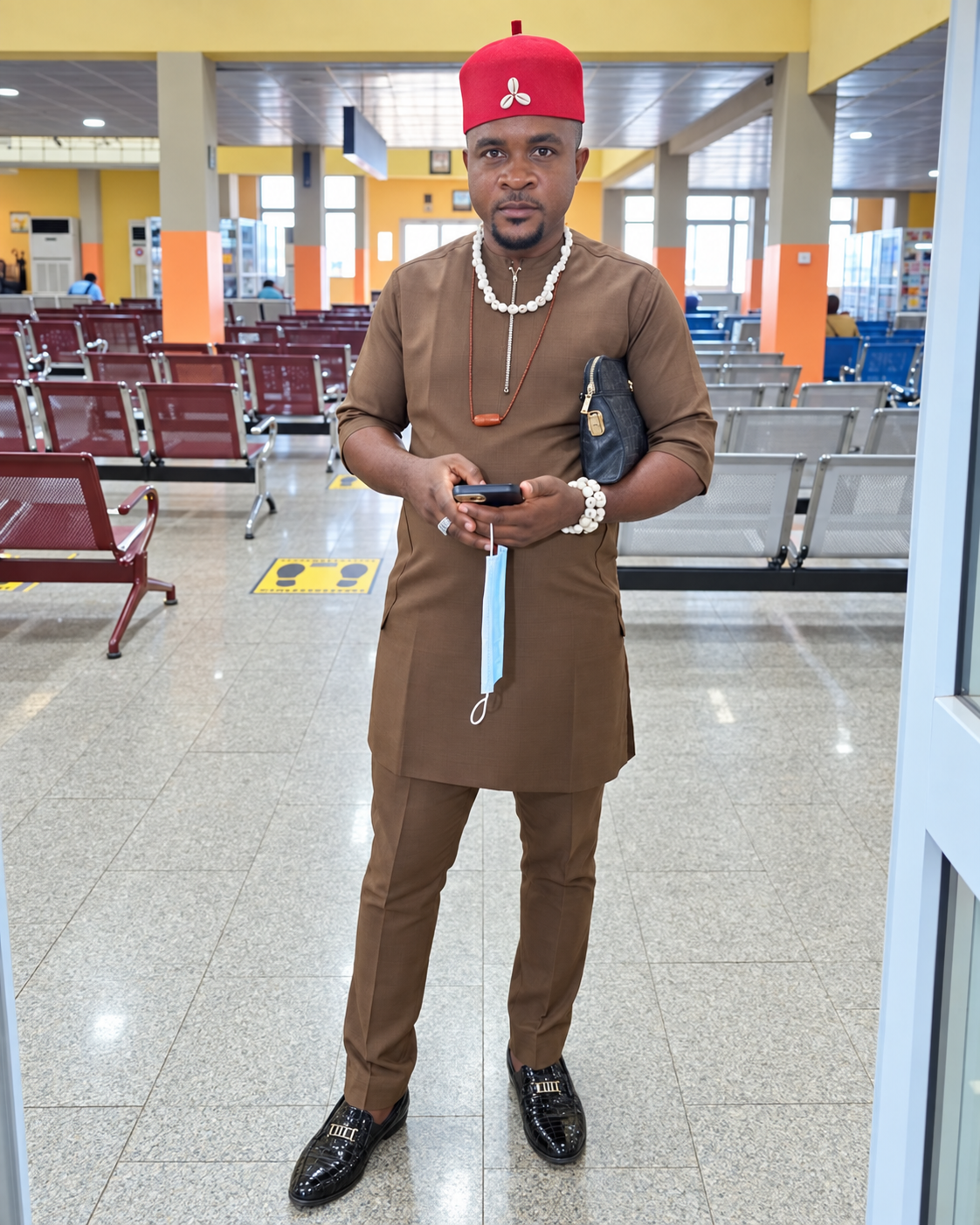 Olisa Ernest Onyeka in brown traditional attire and red cap